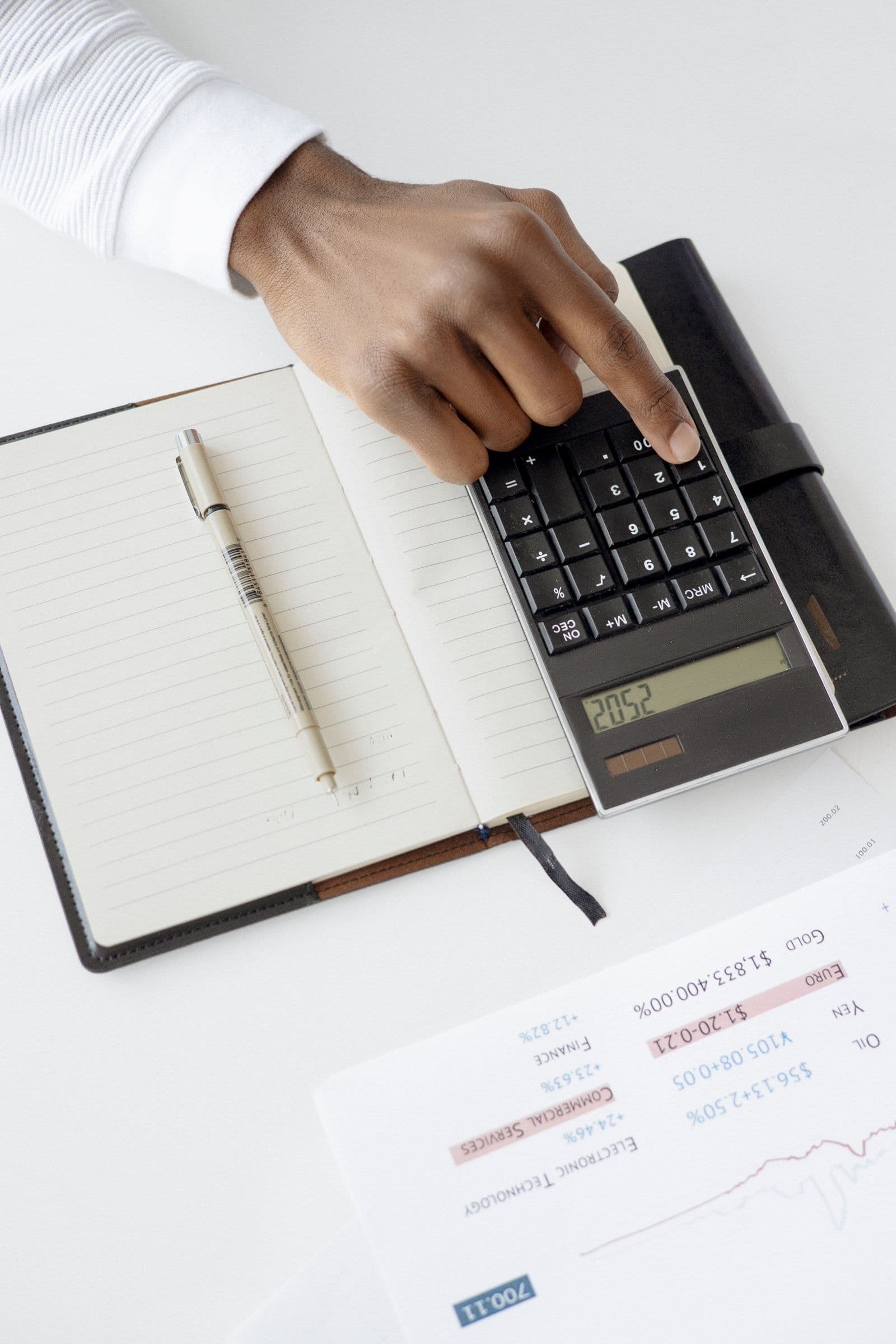 A person checking a budget with a calculator